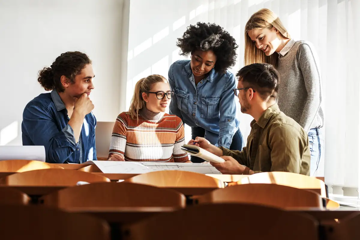 Students collaborating around a table in a lecture hall