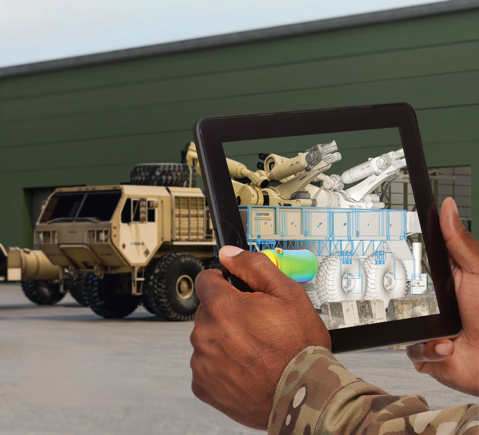 Soldier using a tablet to view a digital twin of manufacturing equipment in front of a military vehicle at a forward operating site
